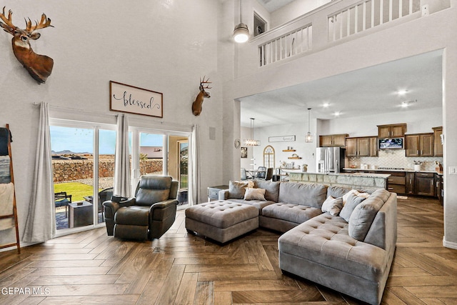 living room featuring a towering ceiling and dark parquet floors