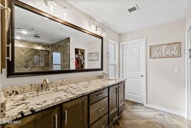 bathroom featuring walk in shower, vanity, and parquet flooring