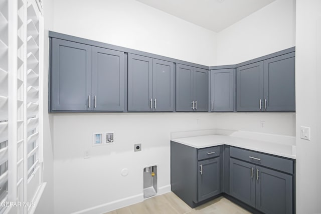 clothes washing area featuring gas dryer hookup, light hardwood / wood-style flooring, hookup for a washing machine, cabinets, and hookup for an electric dryer