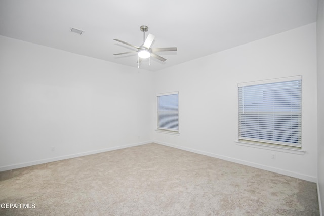 carpeted spare room featuring ceiling fan