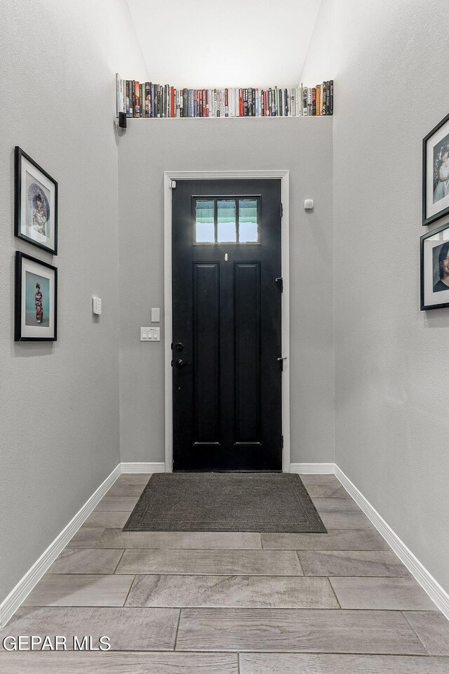 entryway featuring light wood-type flooring and lofted ceiling