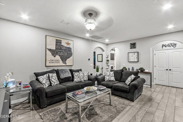 living room with light hardwood / wood-style flooring and ceiling fan