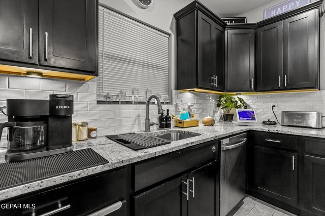 kitchen with dishwasher, light stone counters, sink, backsplash, and wall oven