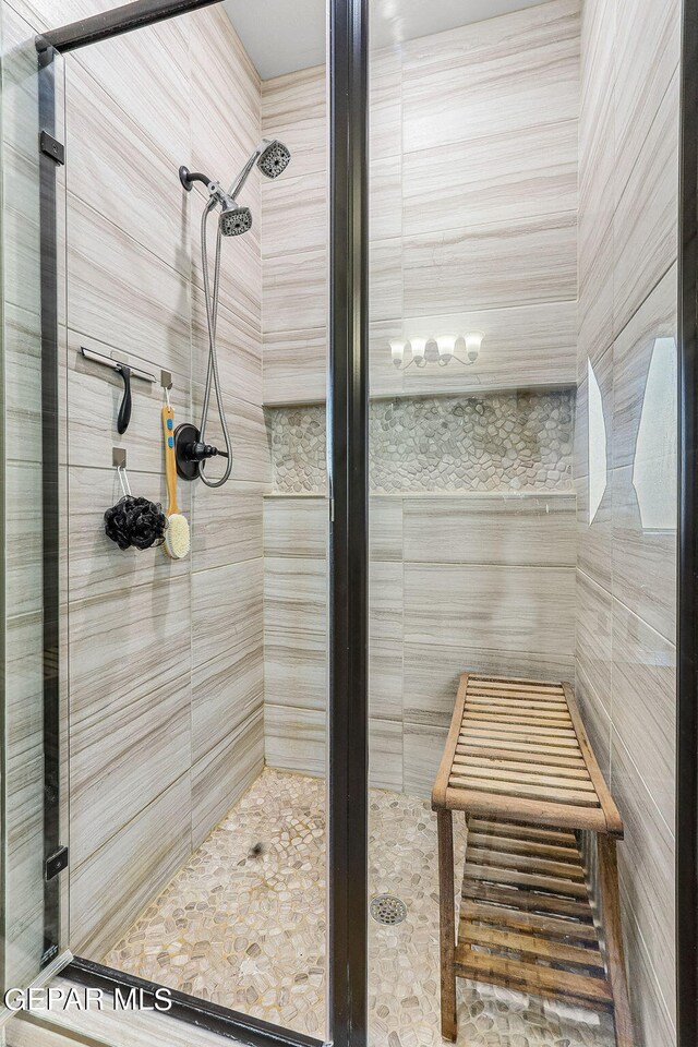 bathroom with tile walls and an enclosed shower