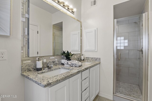 bathroom with decorative backsplash, an enclosed shower, and vanity