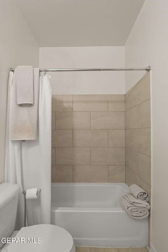 bathroom with shower / tub combo and toilet