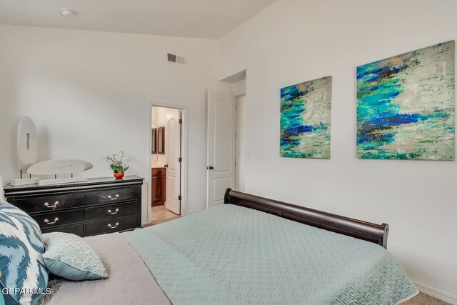 carpeted bedroom with lofted ceiling and ensuite bathroom