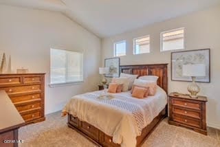 carpeted bedroom with lofted ceiling