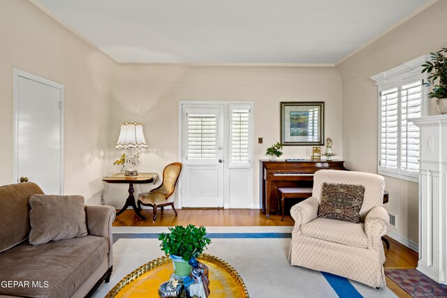 living room with hardwood / wood-style flooring, plenty of natural light, and crown molding