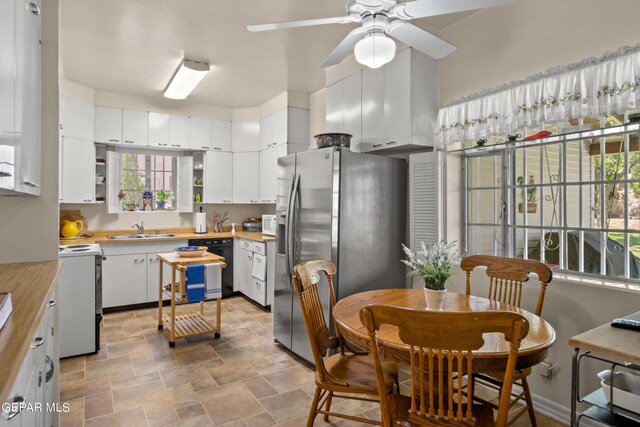 kitchen with stainless steel fridge, white cabinetry, white electric range oven, ceiling fan, and sink