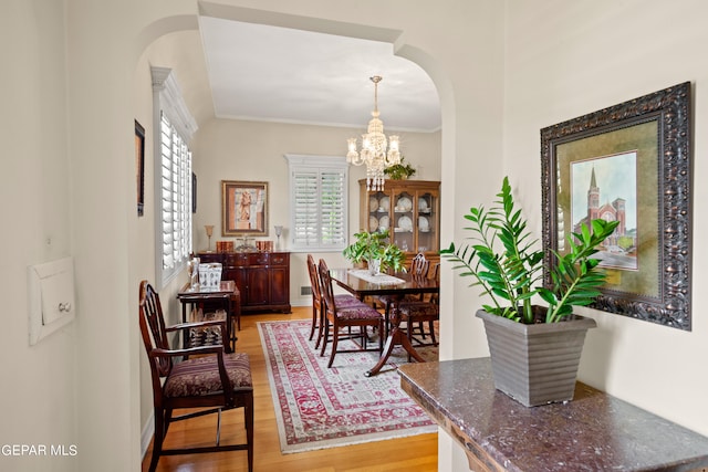 dining area with an inviting chandelier, hardwood / wood-style flooring, and crown molding