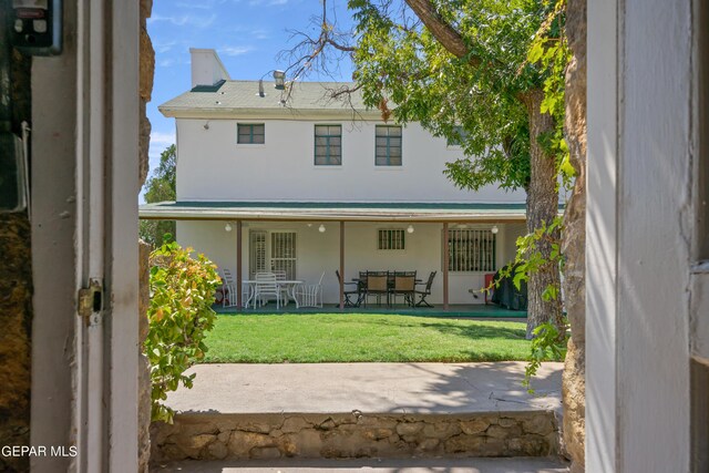 rear view of house with a lawn and a patio area