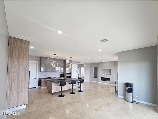 kitchen with a fireplace, a center island, and hanging light fixtures