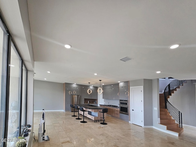 kitchen featuring double oven, a center island, and pendant lighting