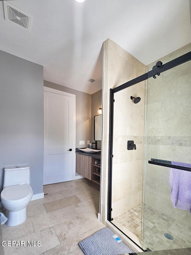 bathroom featuring toilet and a shower with door