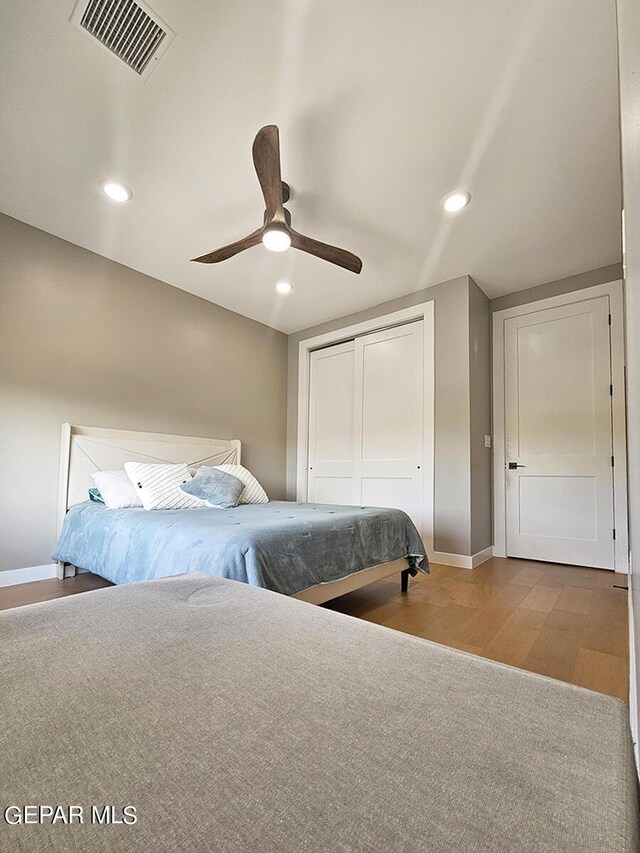 bedroom featuring ceiling fan, a closet, and light wood-type flooring