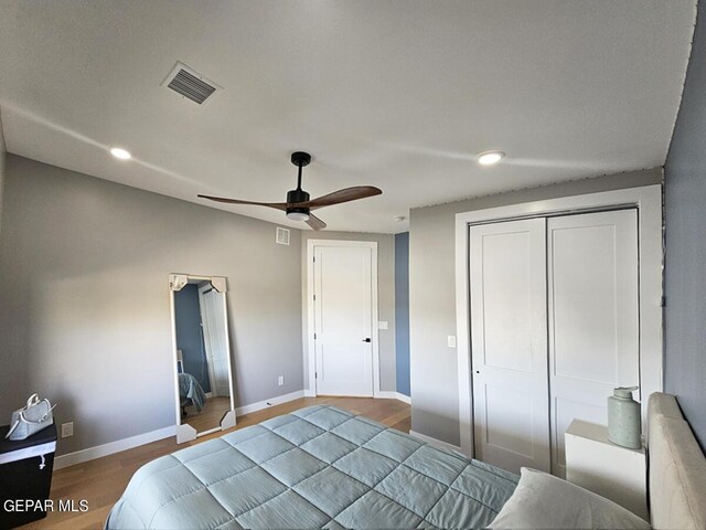 bedroom with hardwood / wood-style flooring, a closet, and ceiling fan