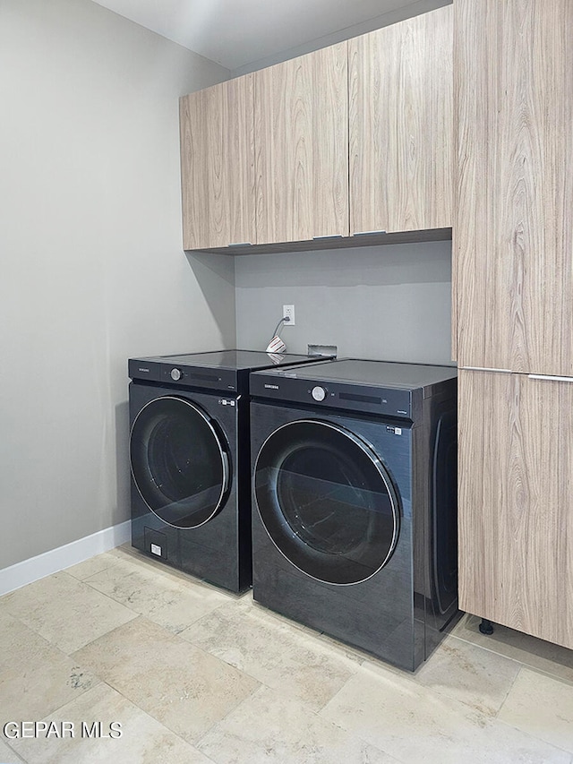 laundry room with washer and dryer and cabinets