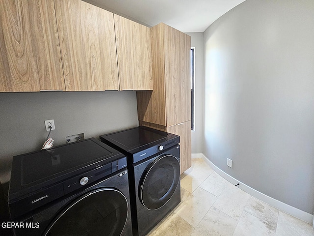 washroom with cabinets and washing machine and clothes dryer