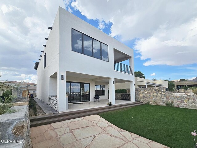 back of house featuring a balcony and a patio