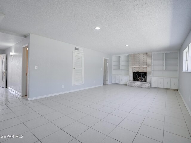 unfurnished living room with a textured ceiling, a fireplace, and built in features