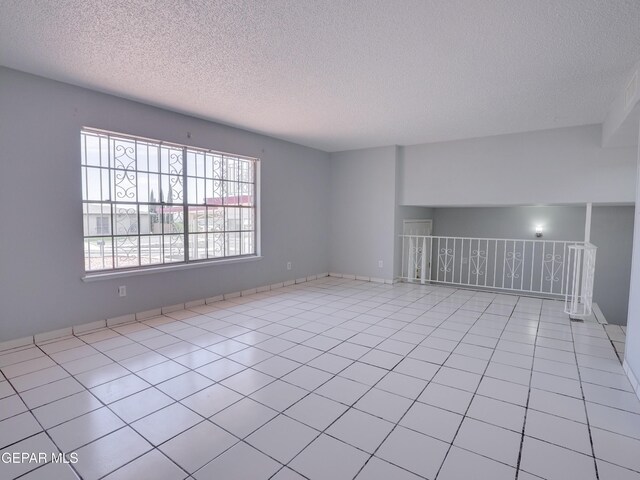 unfurnished living room with a textured ceiling and light tile patterned flooring