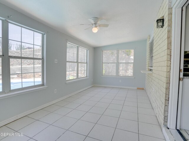 unfurnished sunroom with ceiling fan, vaulted ceiling, and a healthy amount of sunlight