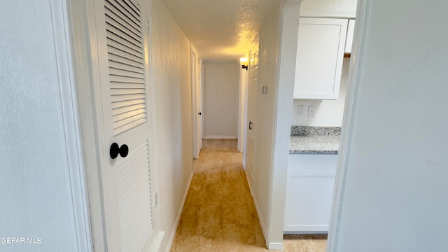 hall featuring a textured ceiling