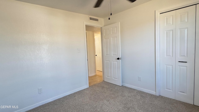 unfurnished bedroom featuring light carpet, a closet, and ceiling fan