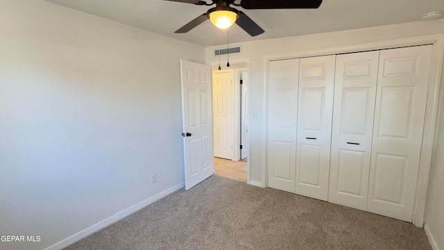 unfurnished bedroom featuring light carpet, a closet, and ceiling fan