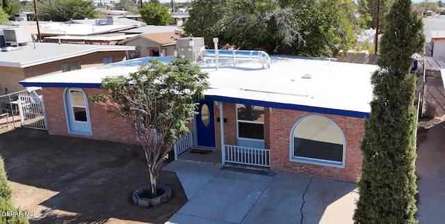 view of front of home with a patio area and an empty pool