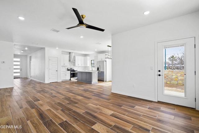 unfurnished living room with ceiling fan