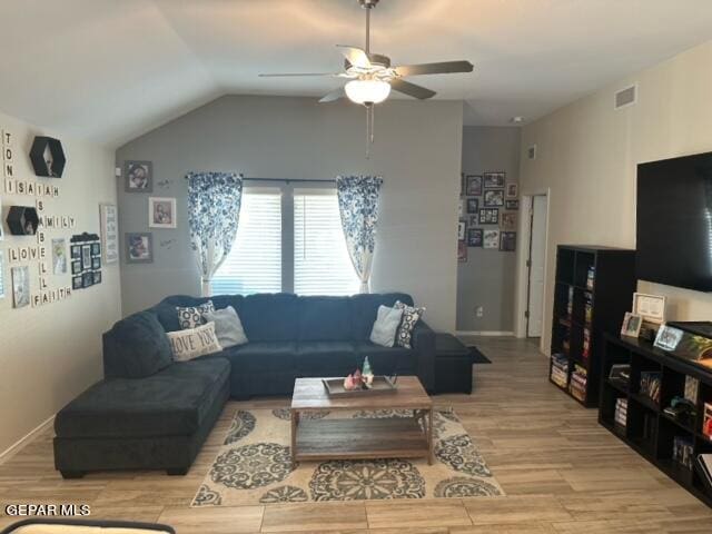 living room with vaulted ceiling, ceiling fan, and light hardwood / wood-style flooring