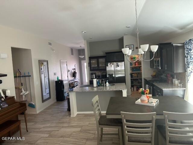 kitchen featuring light stone countertops, decorative backsplash, a center island, and stainless steel appliances