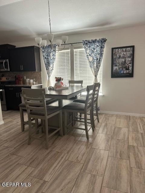 dining area featuring light wood-type flooring and a notable chandelier