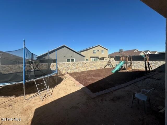 view of yard with a playground and a trampoline