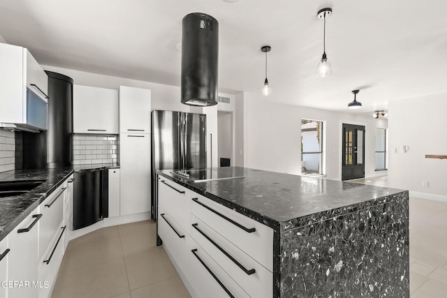 kitchen featuring a spacious island, white cabinets, and backsplash