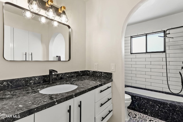 full bathroom with tiled shower / bath combo, vanity, and toilet