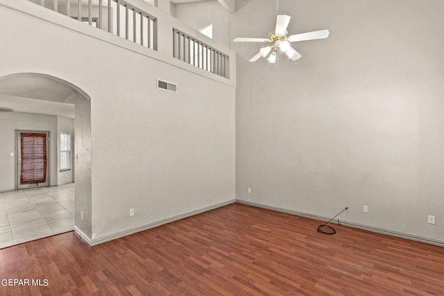 empty room featuring light hardwood / wood-style floors, ceiling fan, and high vaulted ceiling