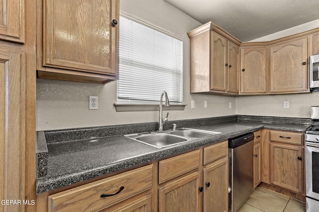 kitchen with stainless steel appliances, a textured ceiling, light tile patterned floors, and sink