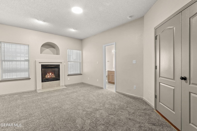 unfurnished living room featuring carpet and a textured ceiling