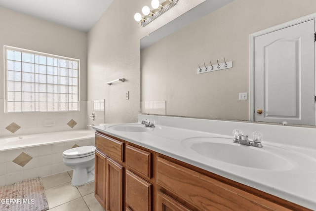 bathroom with tile patterned flooring, tiled bath, vanity, and toilet