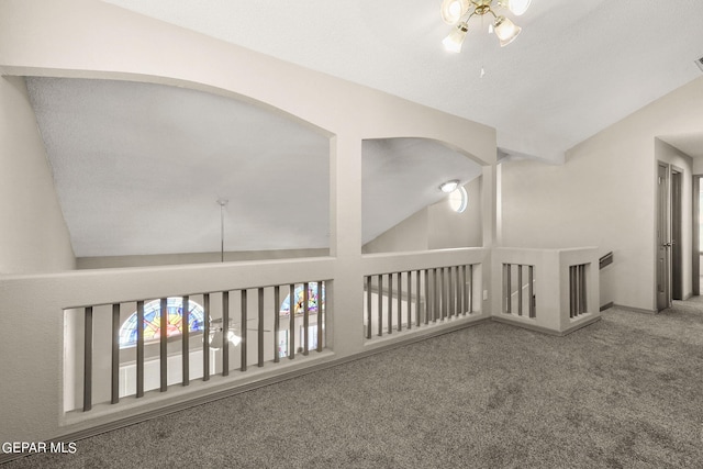 corridor featuring a textured ceiling, lofted ceiling, and carpet flooring