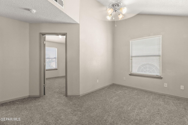 carpeted spare room with ceiling fan, a textured ceiling, and lofted ceiling