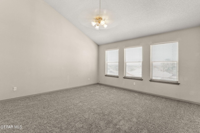 carpeted empty room featuring a textured ceiling and vaulted ceiling