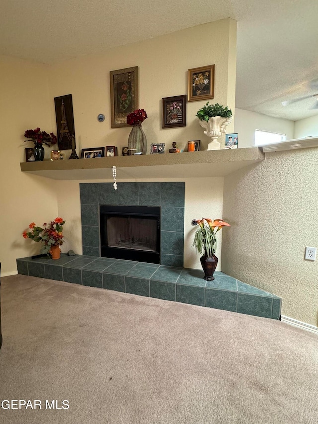 living room with a textured ceiling, a fireplace, and carpet