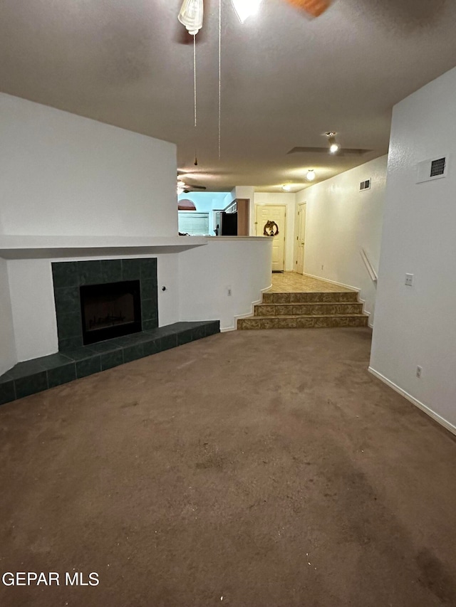 unfurnished living room with ceiling fan and a fireplace