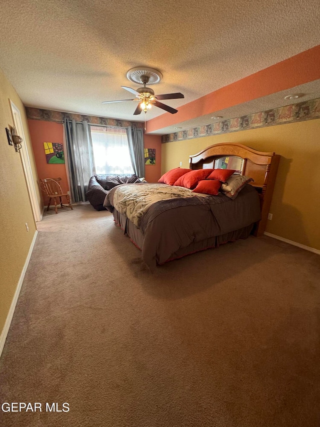 carpeted bedroom featuring ceiling fan and a textured ceiling