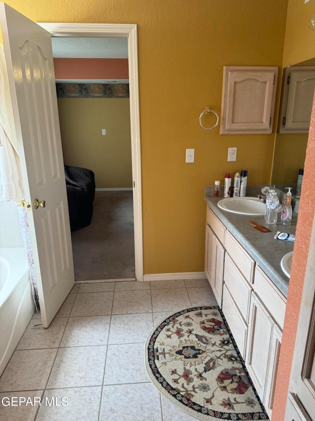 bathroom featuring vanity, tile patterned flooring, and a tub