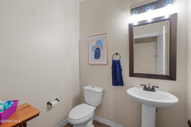 bathroom with hardwood / wood-style floors and toilet